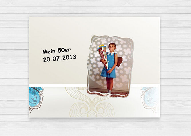 Ein junges Mädchen in einem blauen Kleid hält eine große Schultüte und steht vor einem bunten Hintergrund. Oben links steht in der Schrift: 'Mein 50er 20.07.2013'.