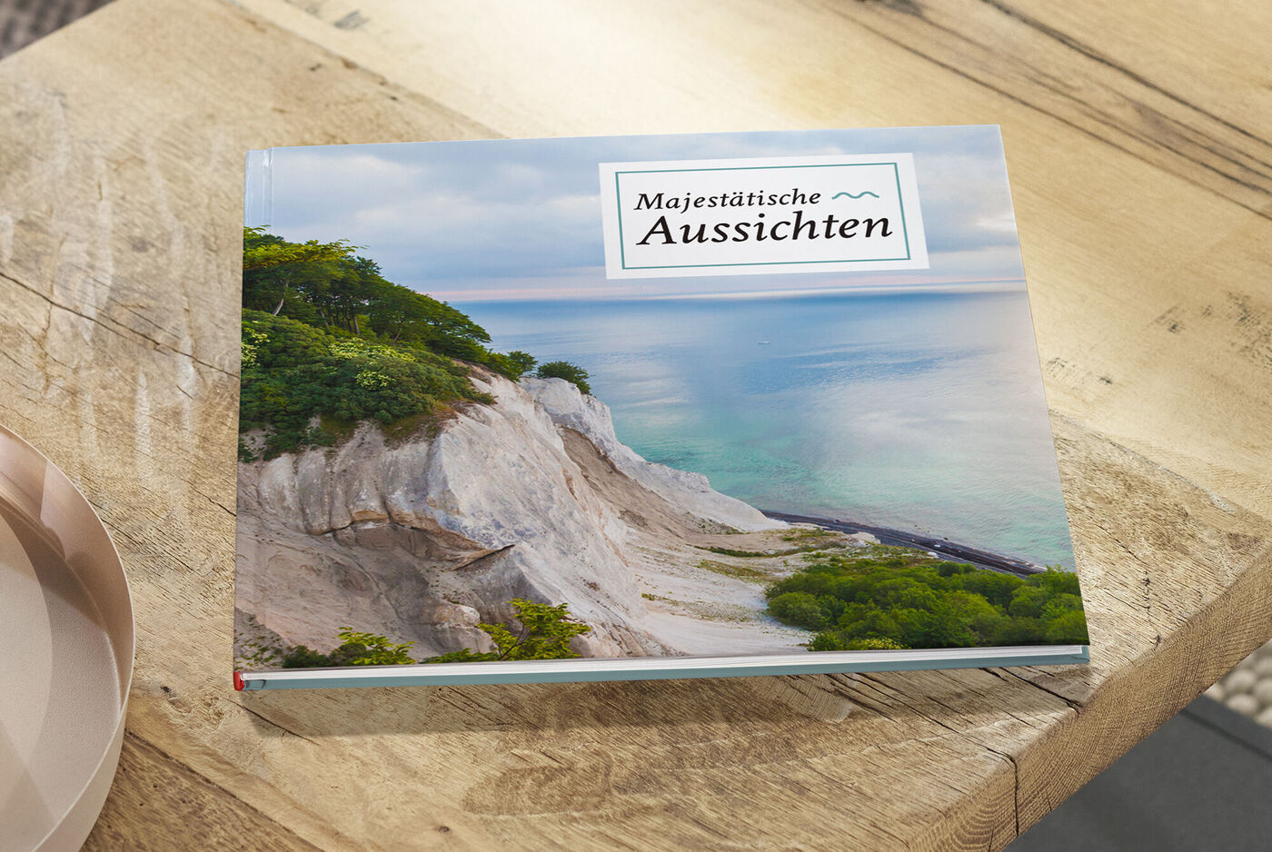 CEWE Fotobuch mit dem Titel 'Majestätische Aussichten' auf einem Holztisch