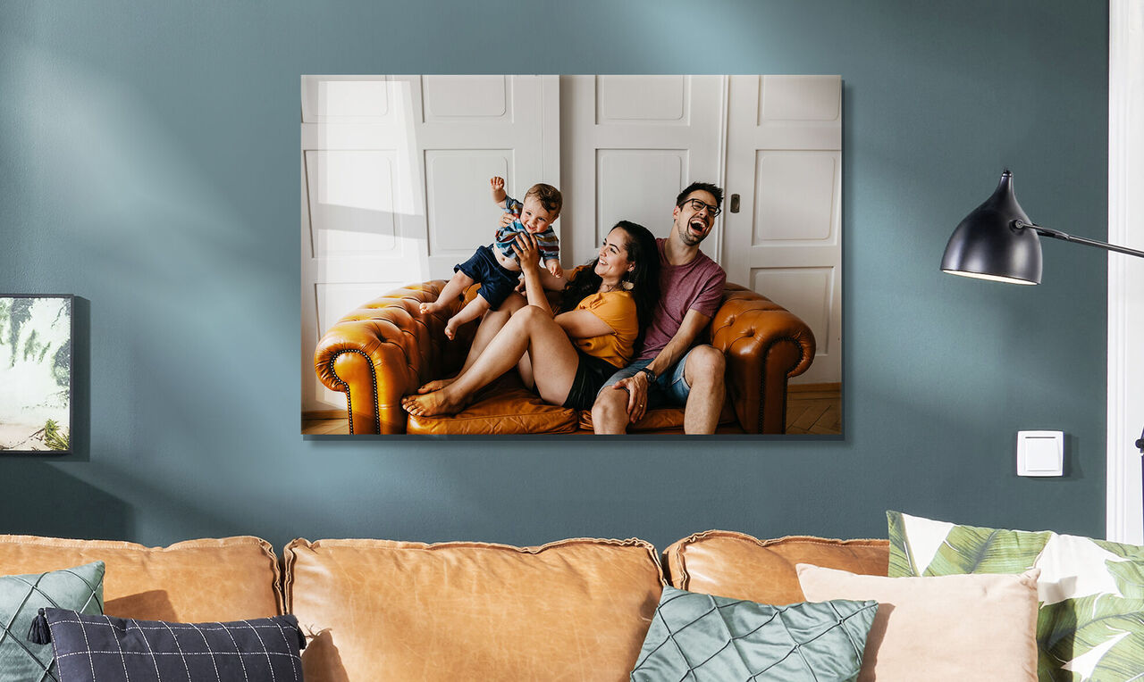 Eine Familie genießt einen fröhlichen Moment auf einem beigen Ledersofa in ihrem gemütlichen Wohnzimmer.