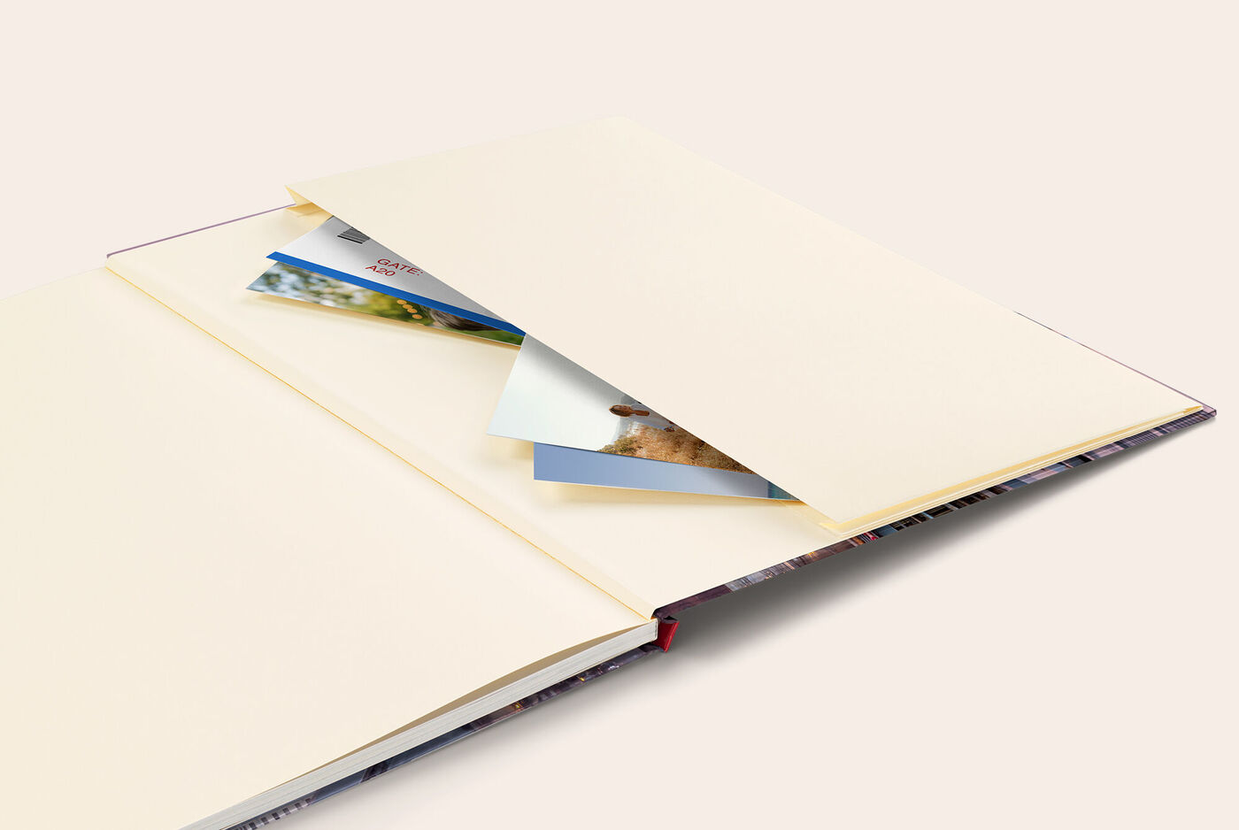 Ein geöffnetes CEWE FOTOBUCH mit leeren Seiten und einer losen Hülle im Inneren, bereit für persönliche Erinnerungen