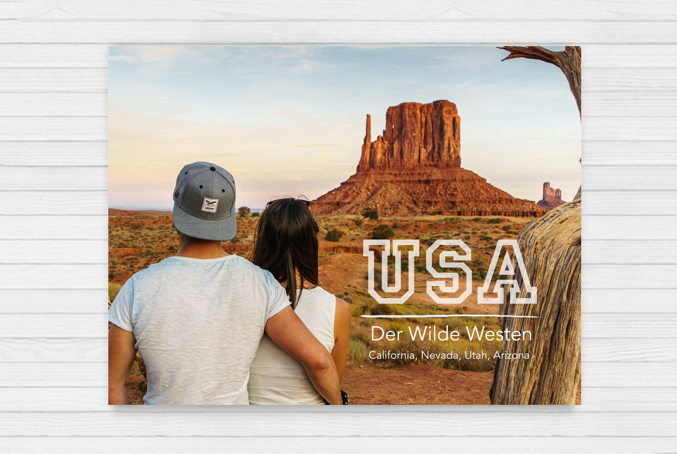 Paar sitzt im Monument Valley in den USA und genießt die Aussicht auf die Statuen