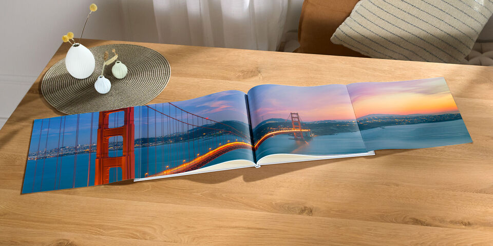 Offenes Fotobuch auf einem Tisch mit Bilder von der Golden Gate Bridge und der Bucht von San Francisco