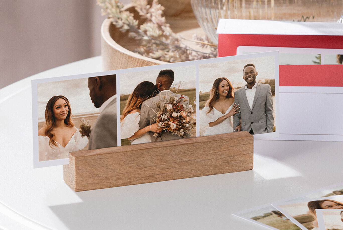 Zwei eingerahmte Fotos auf einem hellen Tisch, die eine romantische Hochzeitsszene zeigen