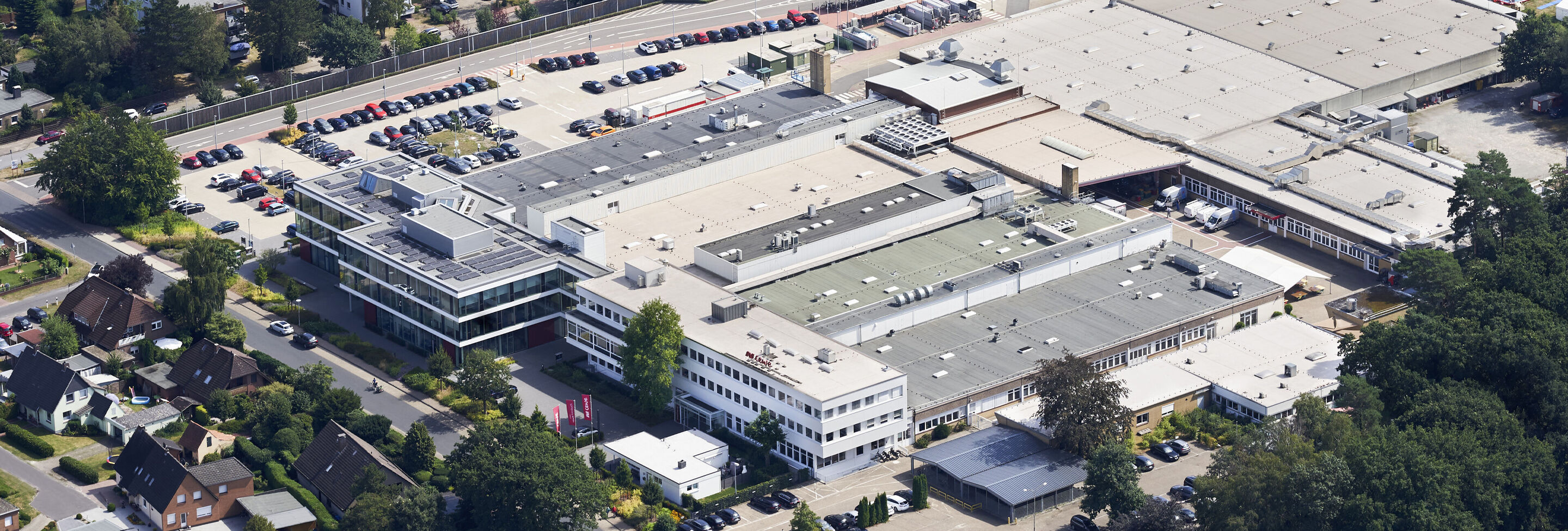 Luftaufnahme des CEWE Unternehmensgeländes mit mehreren Gebäuden und Parkplätzen