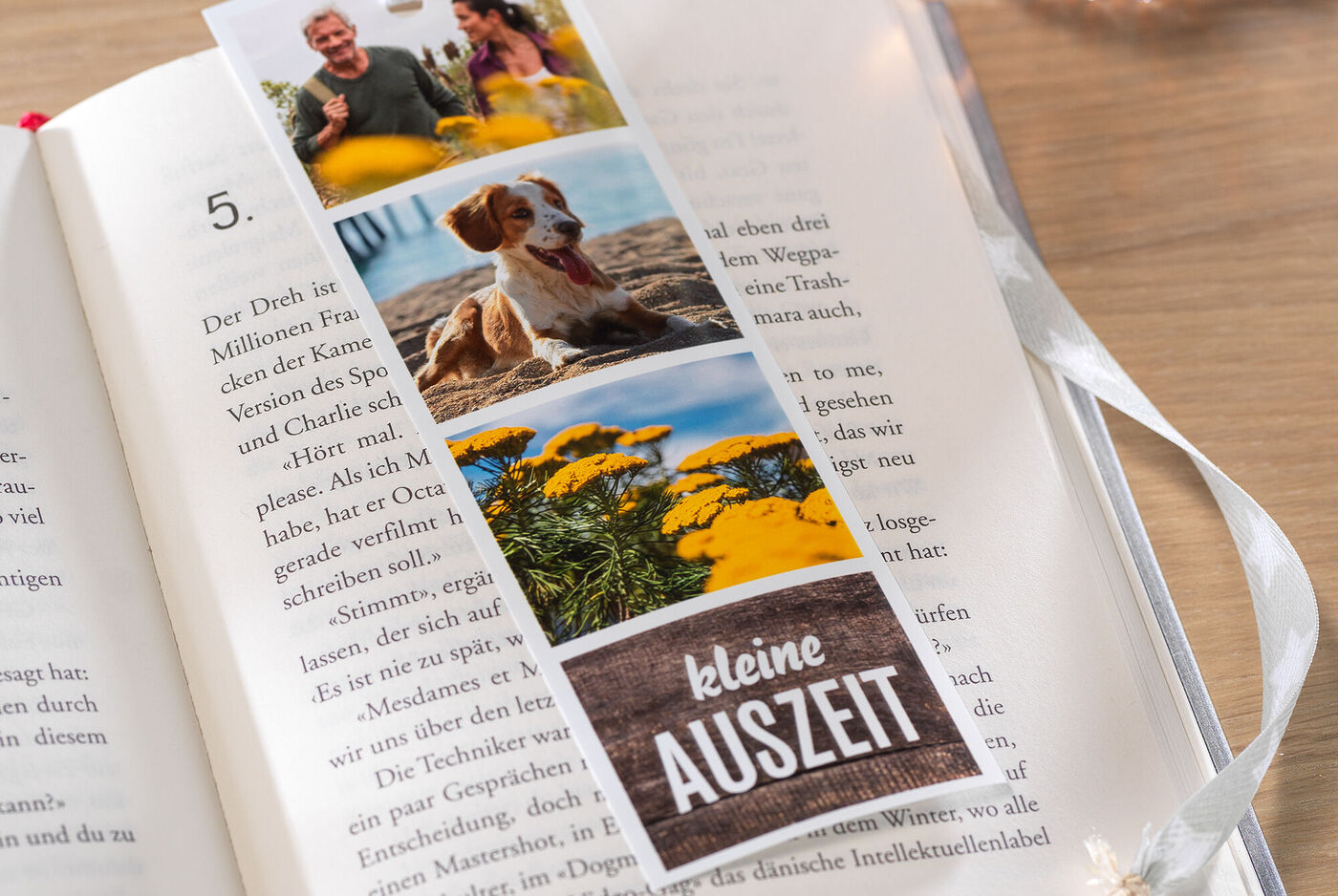 Ein Lesezeichen mit persönlichen Fotos und dem Text "kleine Auszeit". Es zeigt einen Hund, Blumen und glückliche Menschen.