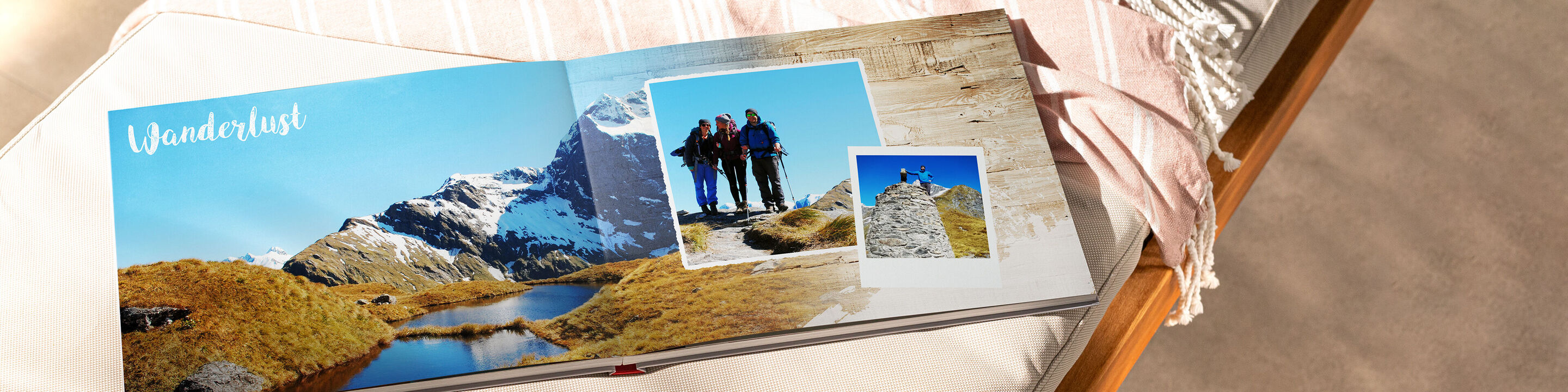 Ein aufgeschlagenes Fotobuch mit Bildern von einem Wanderabenteuer in den Bergen. Die Fotos zeigen eine wunderschöne Landschaft mit Wiesen und Bergen.