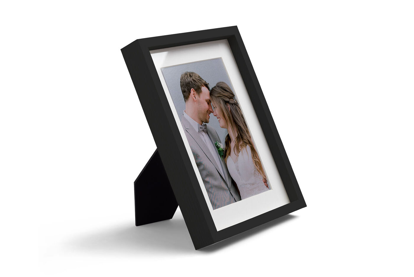 Schwarzer Rahmen mit Fotoabzug von verliebtem Paar im Hochzeitsoutfit