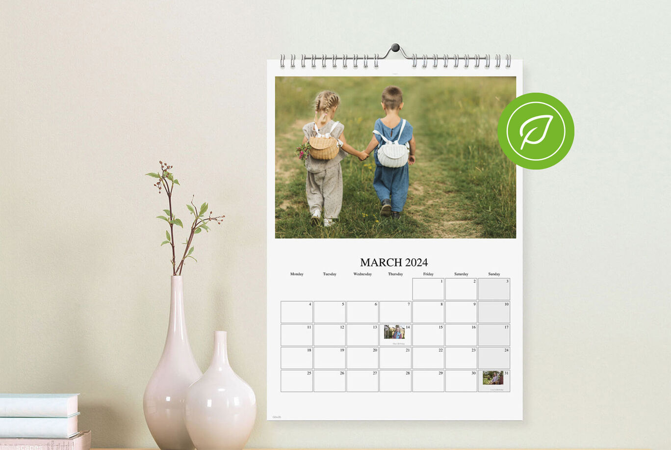 Ein Wandkalender zeigt zwei Kinder in einem grünen Feld, die miteinander sprechen.