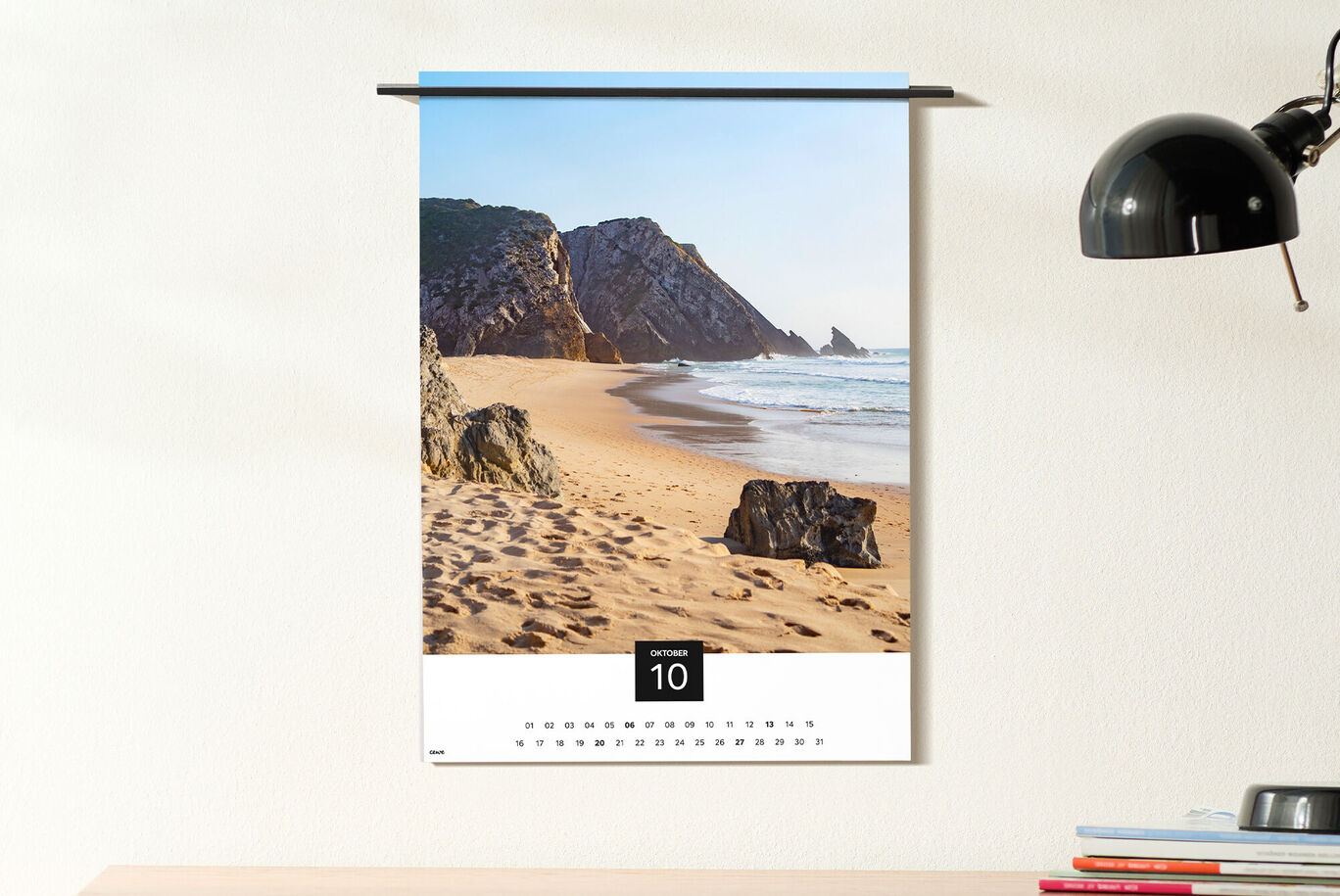 Ein Wandkalender mit einem schönen Strandbild. Die Küstenlandschaft zeigt sanfte Wellen und goldenen Sand an einem sonnigen Tag.