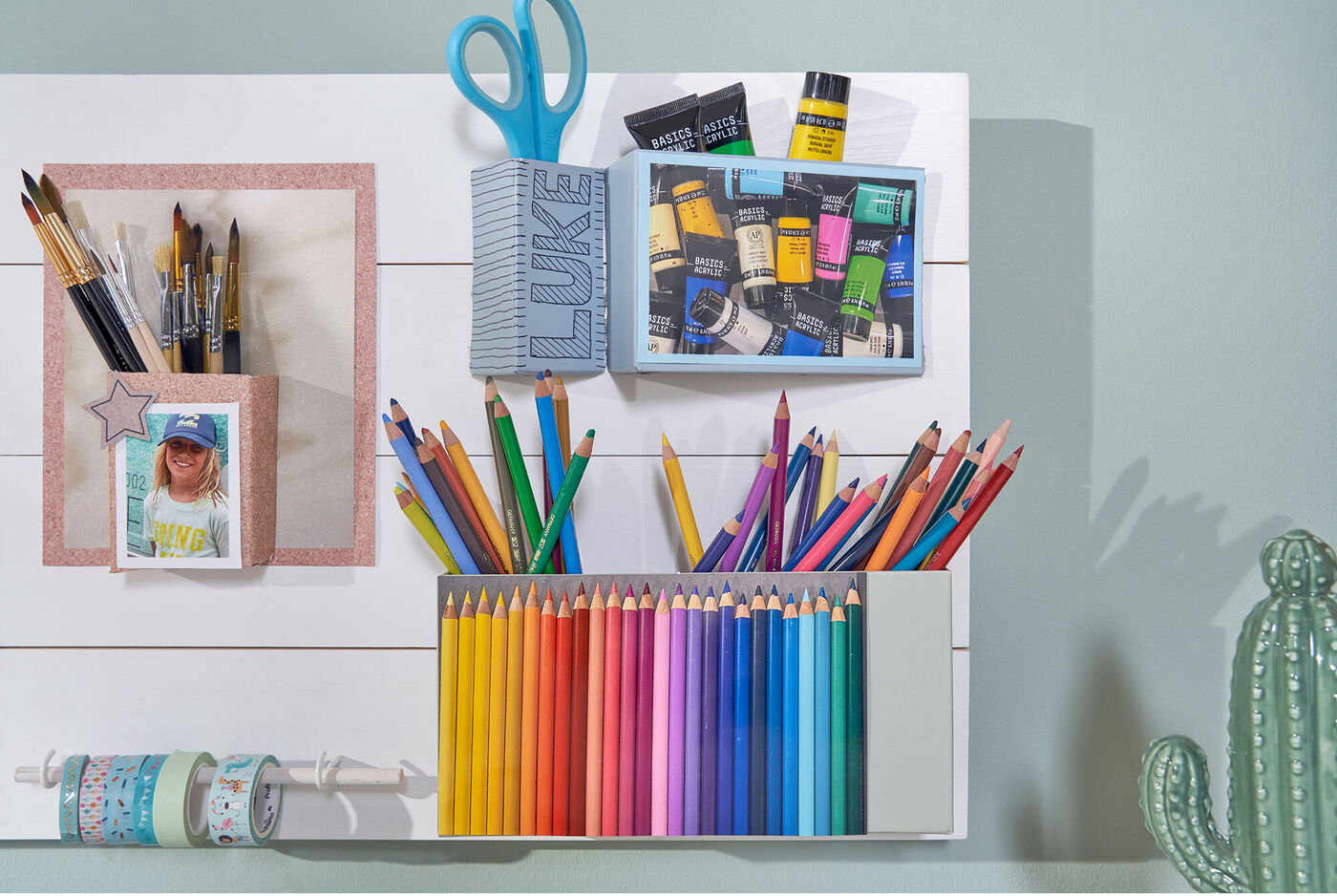 Bunte Stifte, Pinsel und Scheren auf einem Tisch