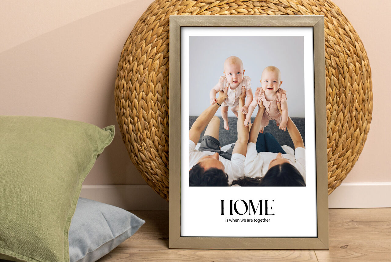 Eine liebevolle Familie hält zwei Babypuppen in der Wohnung und lächelt.