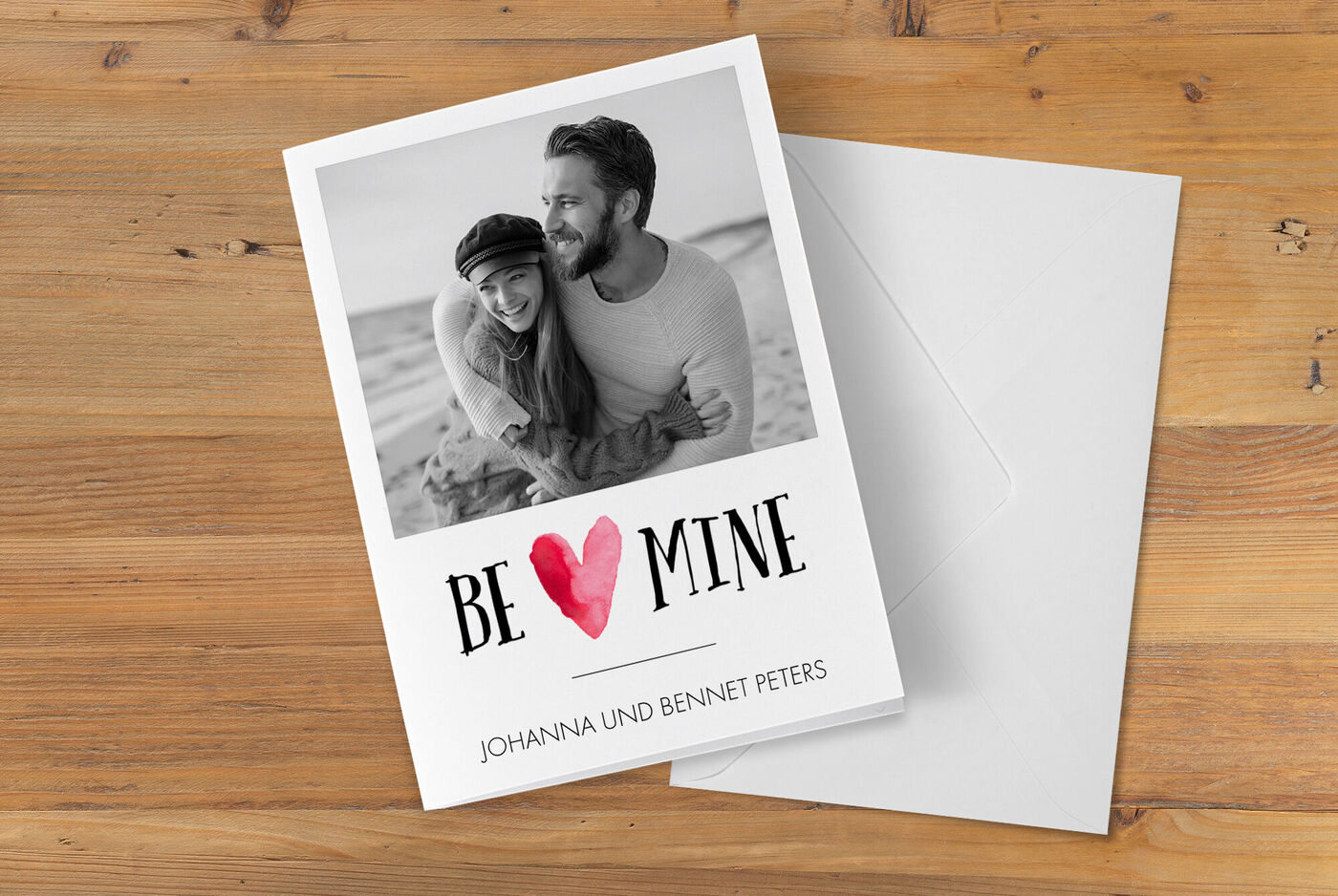 Eine liebevolle Grußkarte mit einem Foto von einem Paar am Strand und dem Schriftzug "BE MINE".