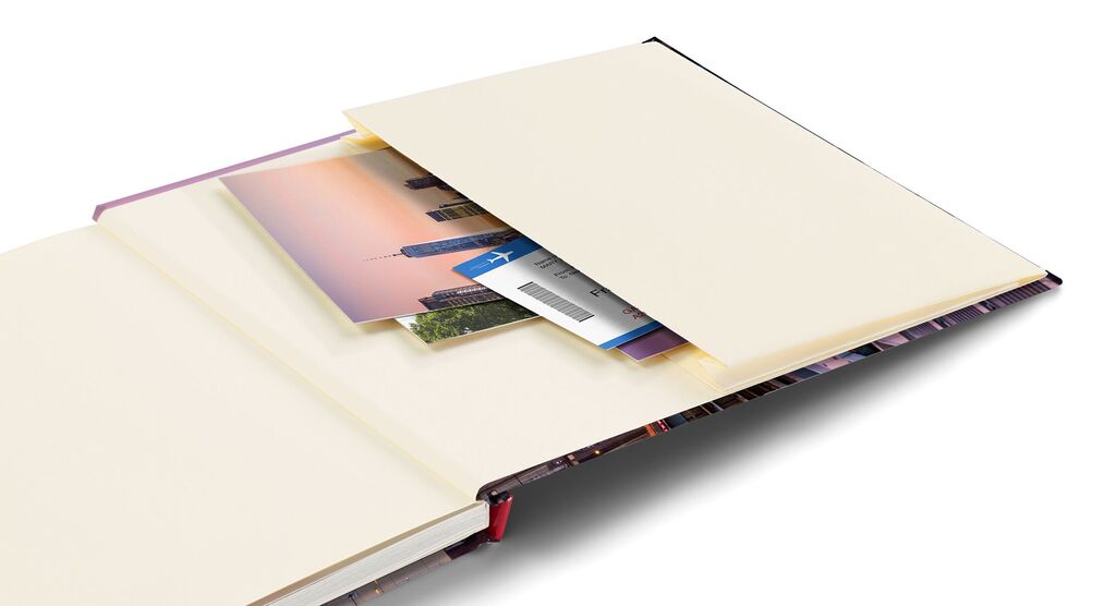 Ein offenes CEWE FOTOBUCH mit leeren Seiten und eingefügten Fotos und Erinnerungen