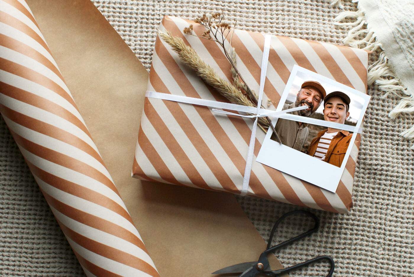 Ein liebevoll verpacktes Geschenk mit gestreiftem Papier, einer Schnur und einer Fotografie.