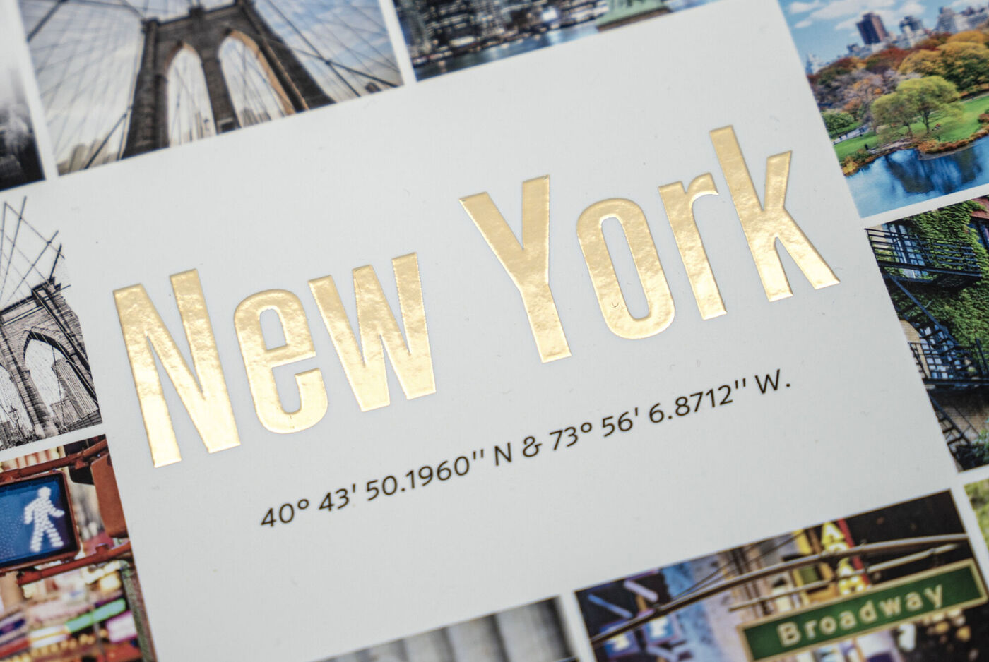 Goldene Schrift mit dem Text 'New York' auf weißem Hintergrund, umgeben von Fotos der Stadt
