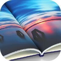 Offenes CEWE FOTOBUCH mit einer Landschaftsaufnahme im Sonnenuntergang
