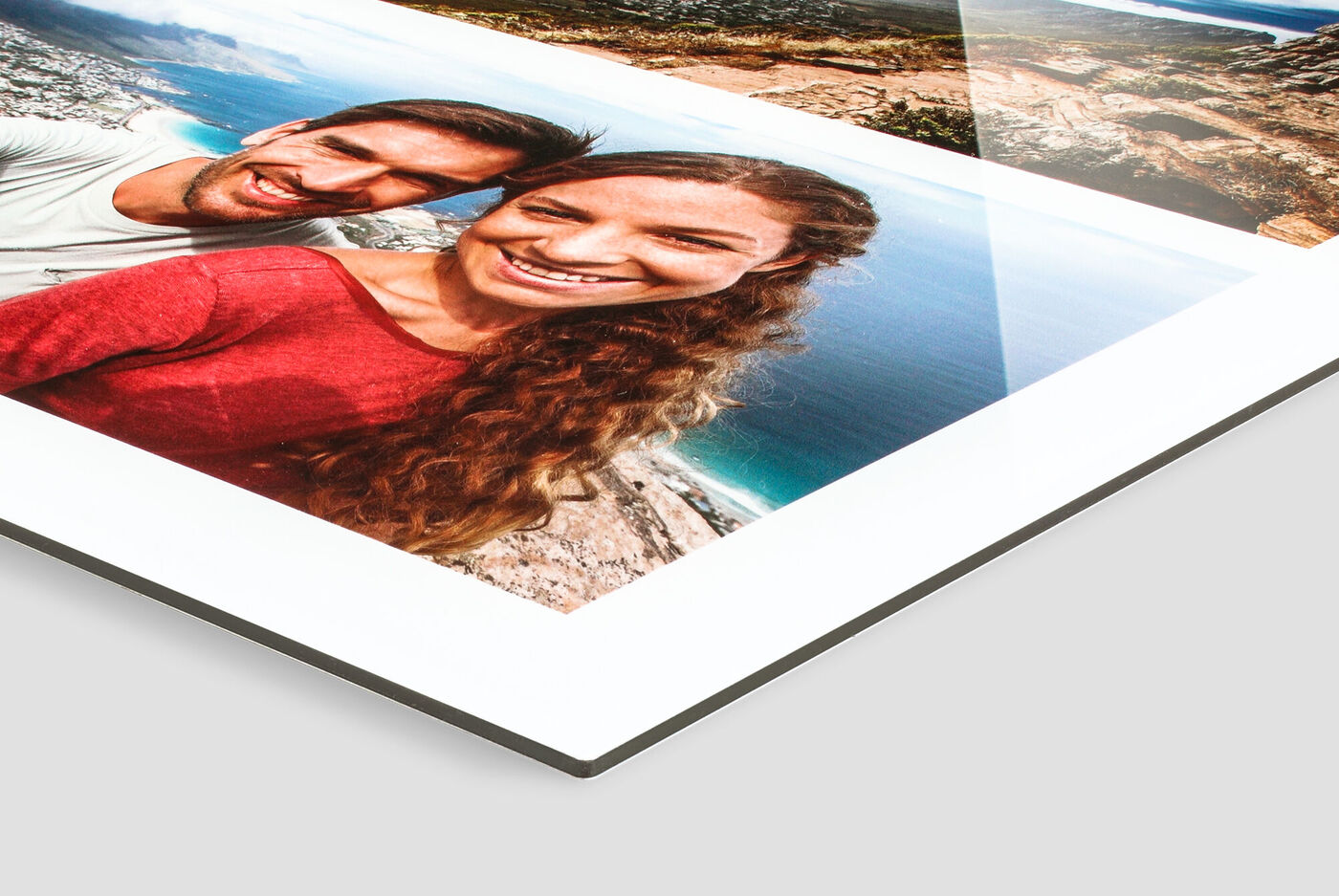 Verliebtes Paar hält ein CEWE Fotobuch mit Urlaubserinnerungen in der Hand