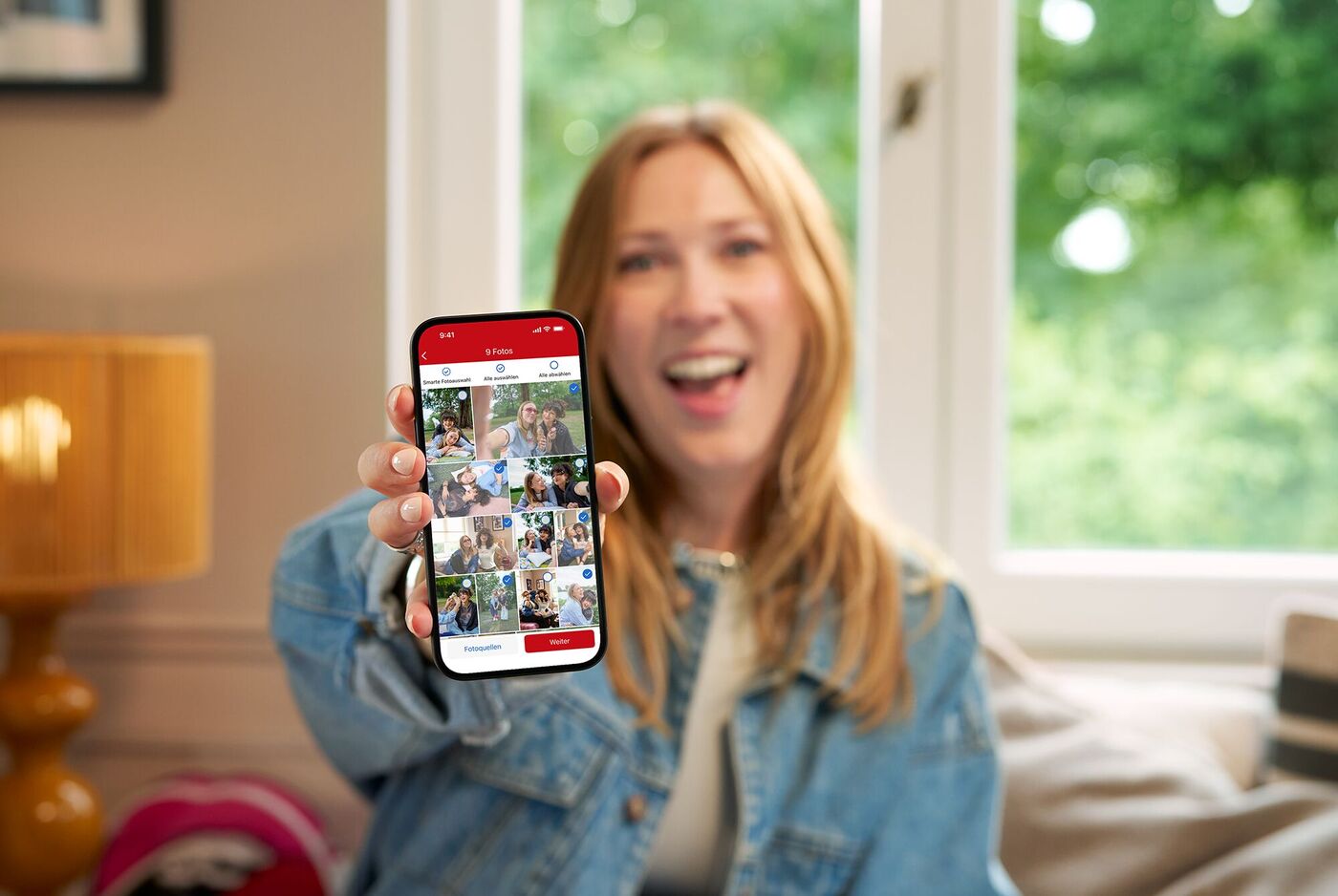 Person zeigt Fotos aus der App auf ihrem Smartphone, drinnen, entspannt