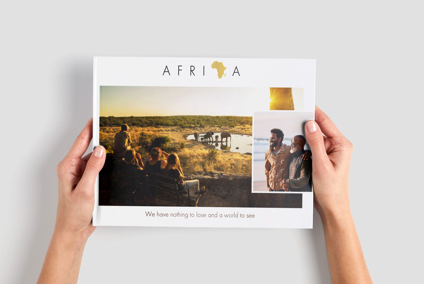 Eine Person hält ein CEWE FOTOBUCH mit Erinnerungen von Afrika in den Händen