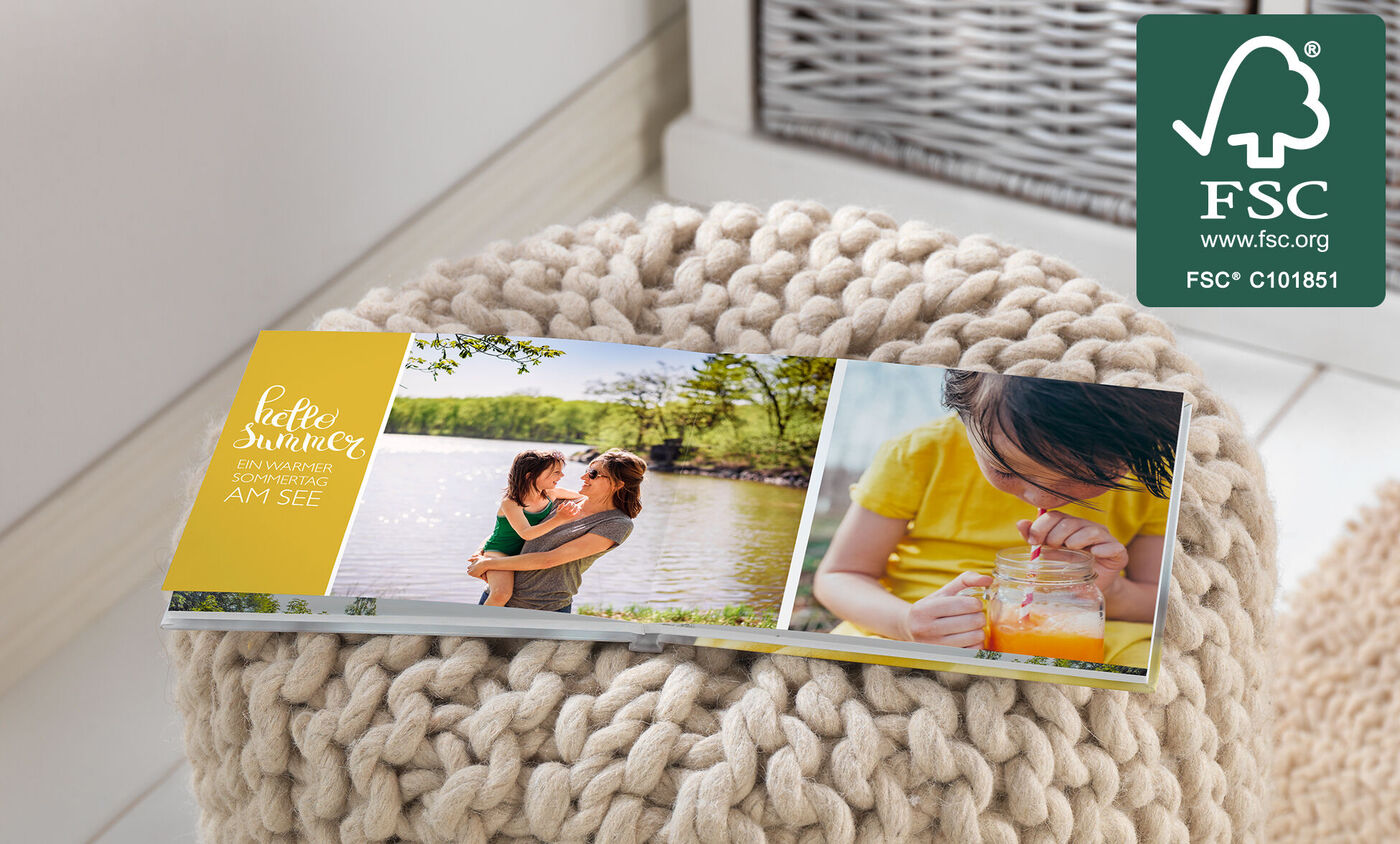 Ein fröhliches Fotobuch mit sommerlichen Erinnerungsmomenten am See. Eine Mutter umarmt ihr Kind und ein Kind trinkt Saft.