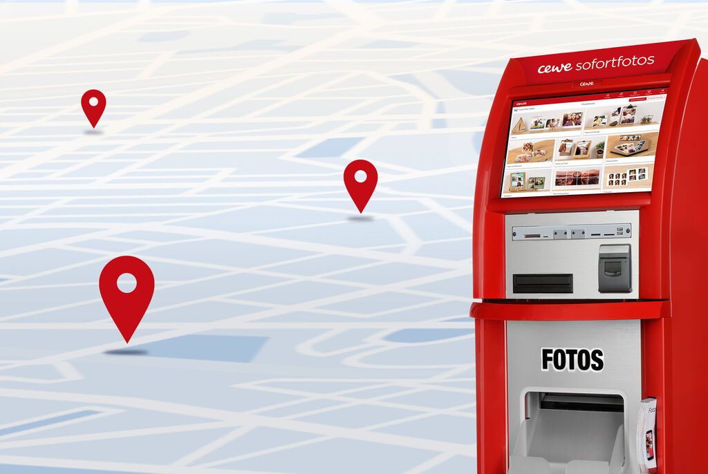 Ein CEWE Sofortfotos-Automat steht vor einer symbolischen Stadtkarte mit Standorten.