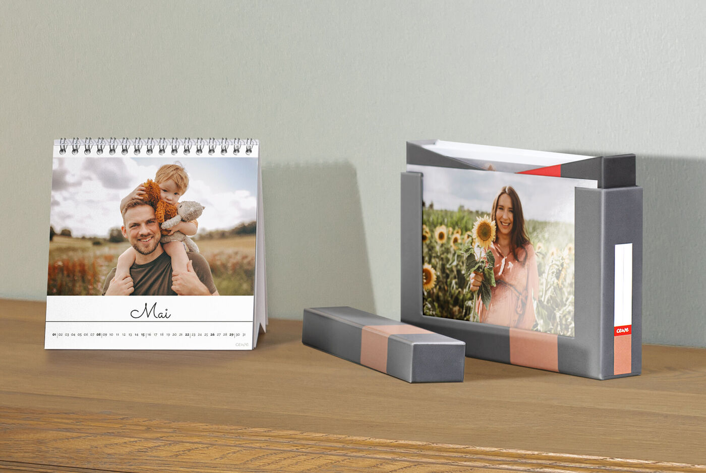 Ein kreativer CEWE Fotokalender steht auf einem Holzregal, daneben liegt eine liebevoll gestaltete CEWE Grußkarte mit einem Schnappschuss eines glücklichen Kindes