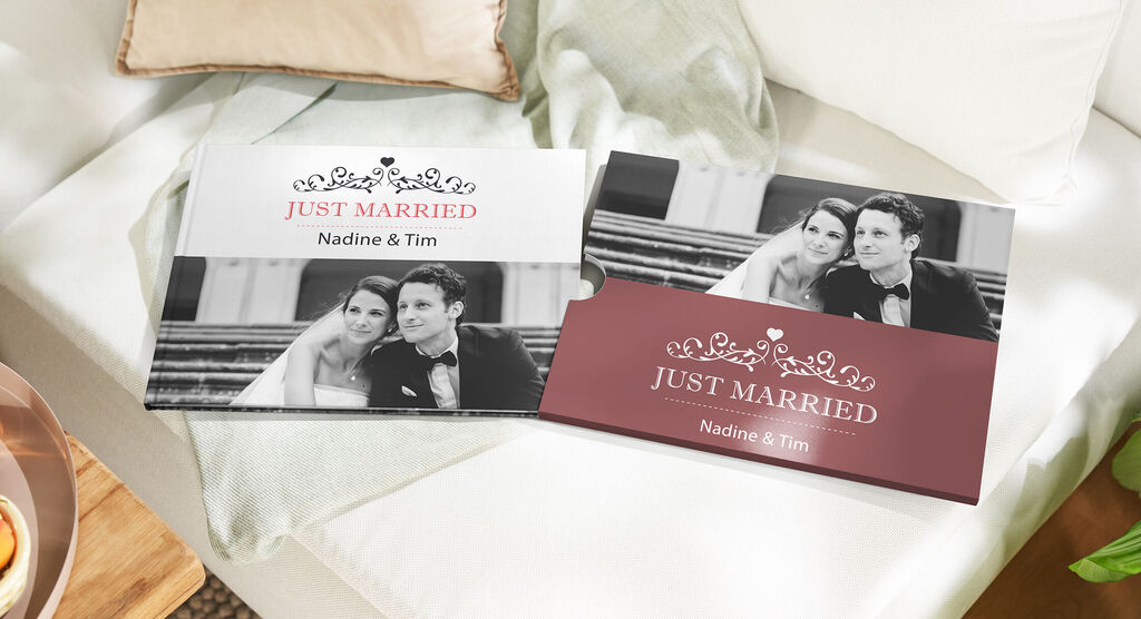 Zwei Hochzeitsalben mit dem Titel 'Just Married' liegen auf einer Couch.