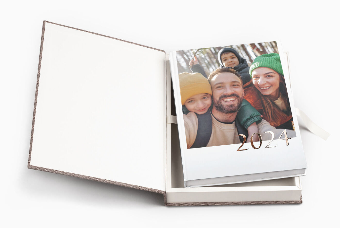 Ein offenes CEWE FOTOBUCH mit einem personalisierten Cover, das die Jahreszahl 2024 zeigt