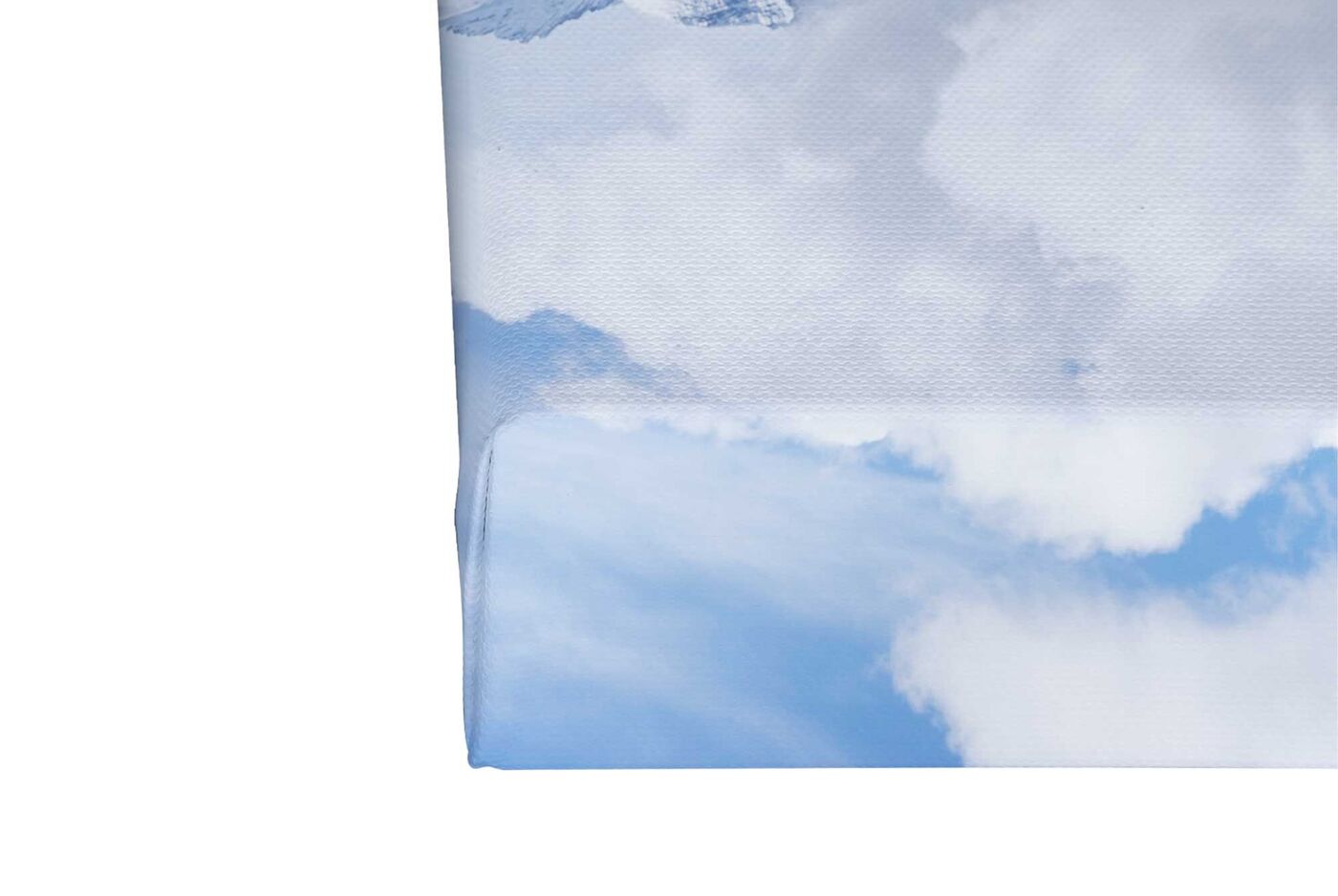 Impression eines CEWE Wandbildes mit sanften, blauen Himmel und weißen Wolken beim Aufhängen.
