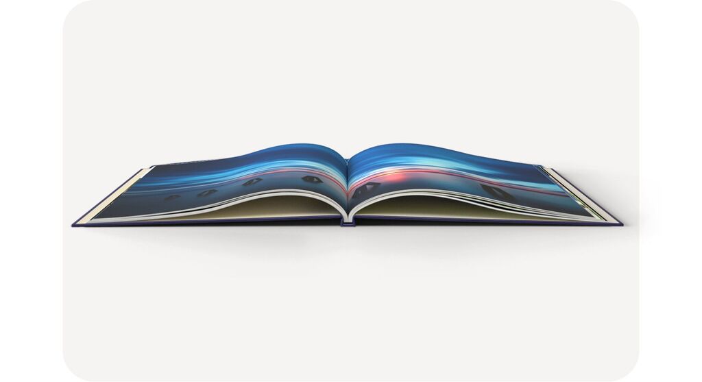 Ein aufgeschlagenes CEWE FOTOBUCH mit bunten Fotografien auf den Seiten