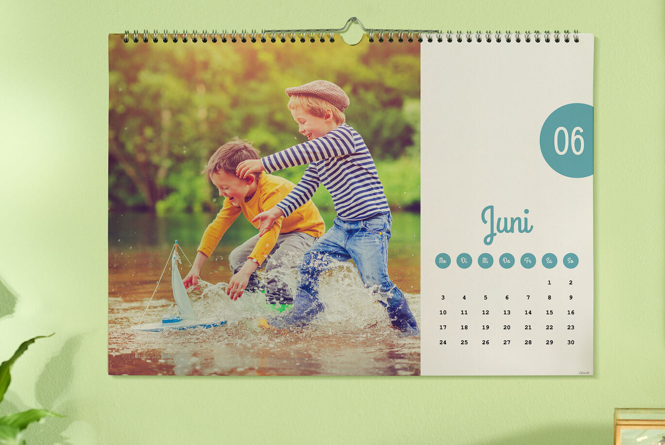 Zwei Kinder spielen im Wasser mit einem Boot auf einem Kalender für den Monat Juni