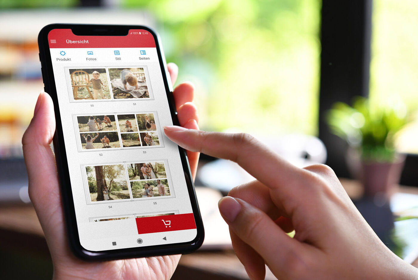 Hand eines Nutzers tippt auf die Bildschirmansicht einer Foto-App mit verschiedenen Bildern und Vorschauen.