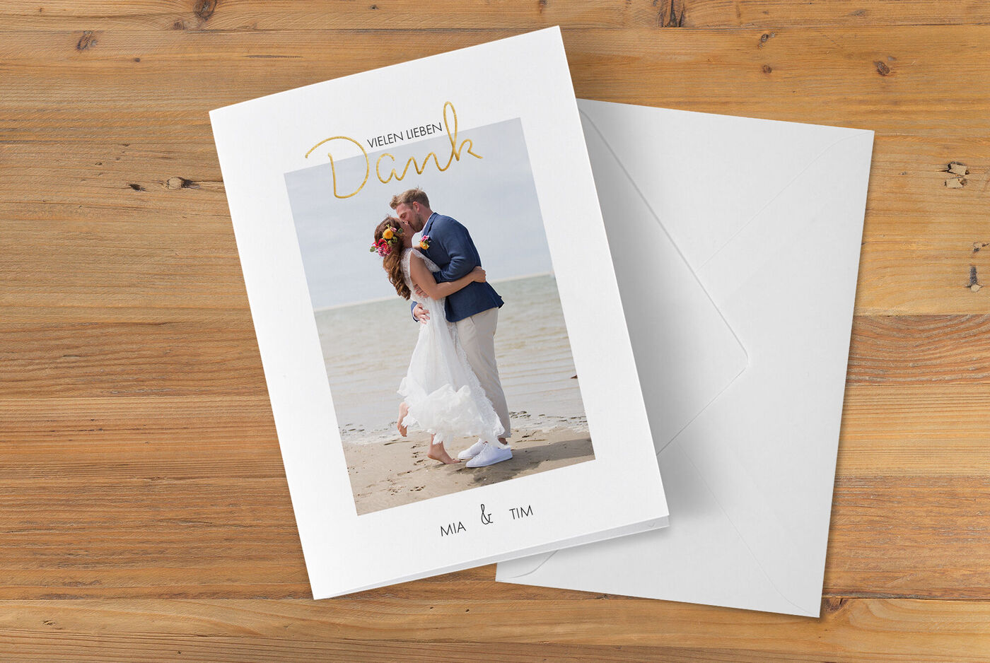 Hochzeitspaar im Sand, umarmt sich dankbar am Strand