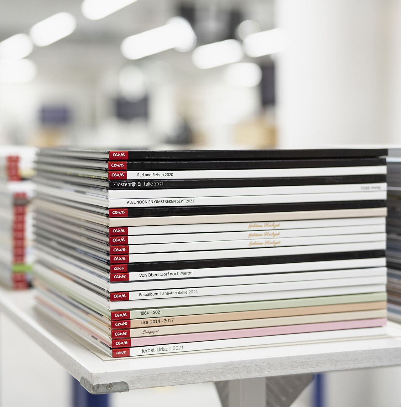 Gestapelte CEWE Fotobücher in verschiedenen Farben und Größen