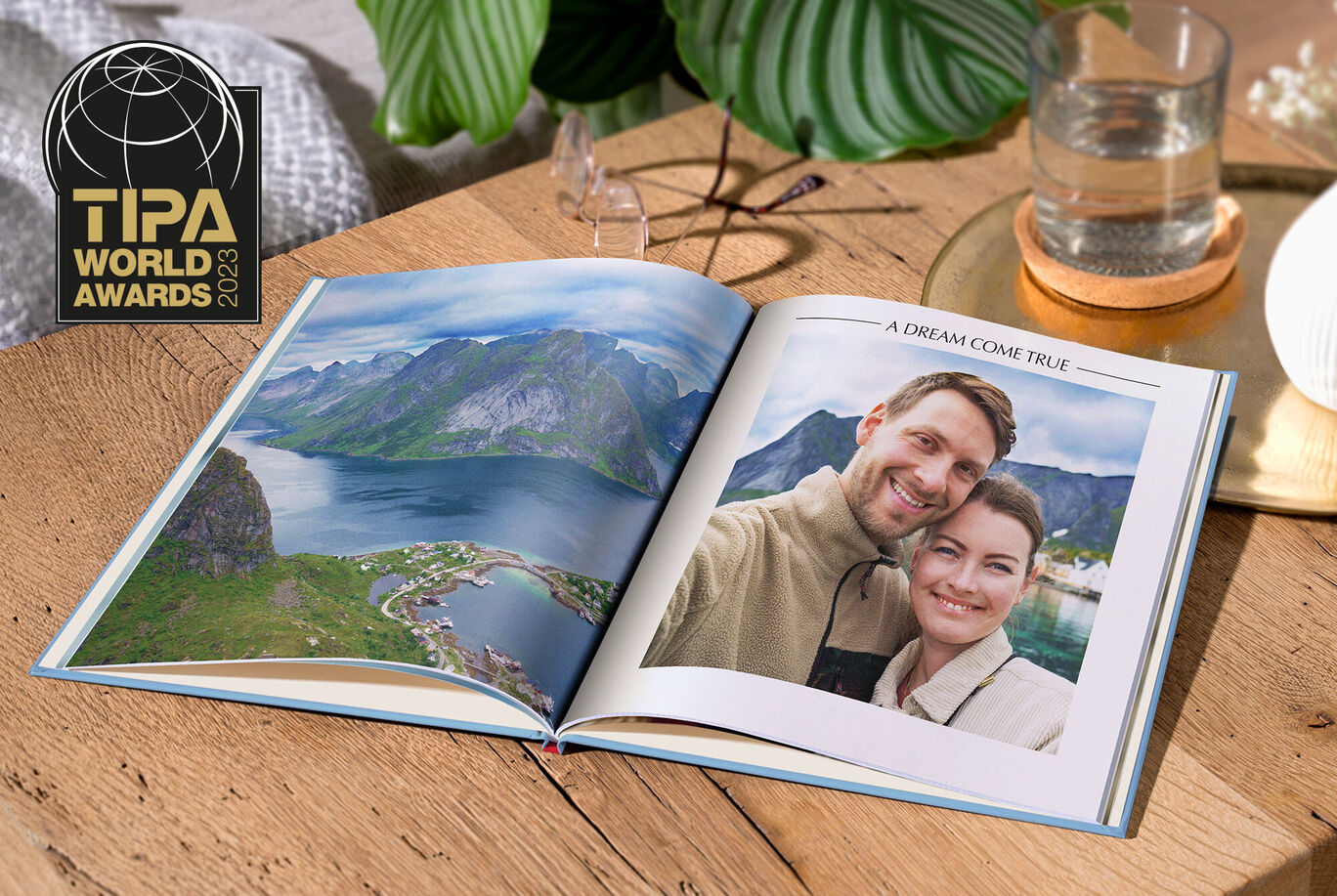 Ein geöffnetes Fotobuch mit einer schönen Landschaft und Erinnerungsfotos.