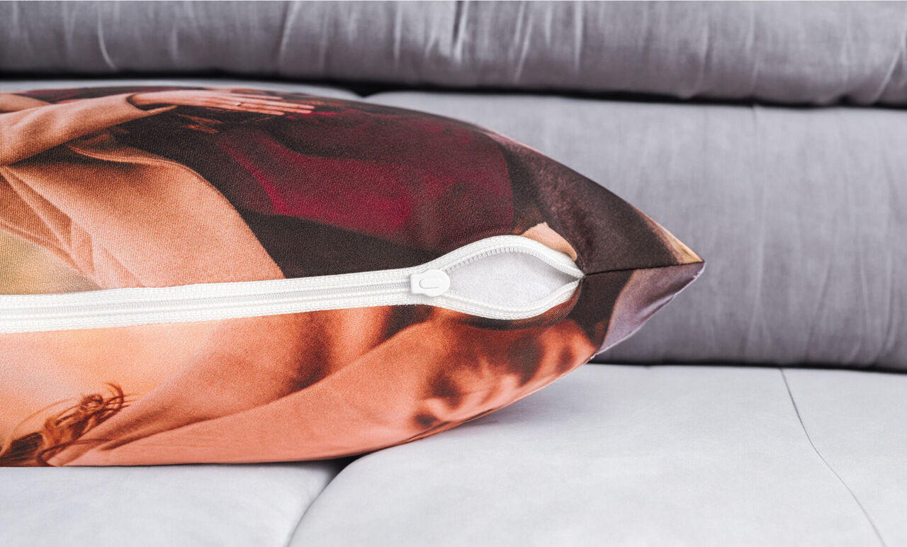 Ein wunderschöner Kissenbezug mit lebendigen Farben und einem Reißverschluss, auf einem hellen Sofa platziert.