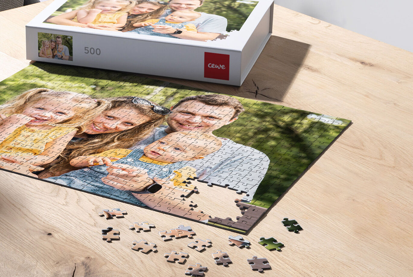 Familie löst ein CEWE Puzzle auf einem Tisch, fröhliche Momentaufnahme