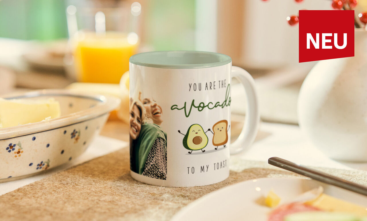 Fototasse mit fröhlichem Paar und lustigem Avocado-Toast Spruch und Innenfarbe in Pastell Grün steht auf dem Frühstückstisch