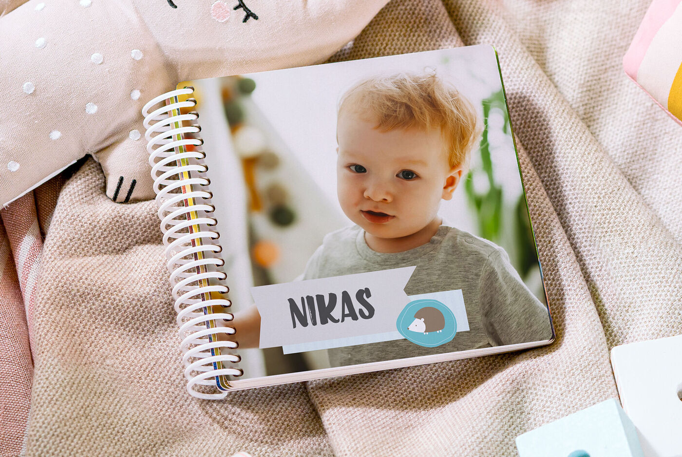 Ein geöffnetes Fotobuch mit einem Kind auf der Seite. Es ist liebevoll gestaltet mit dem Namen "Niklas".