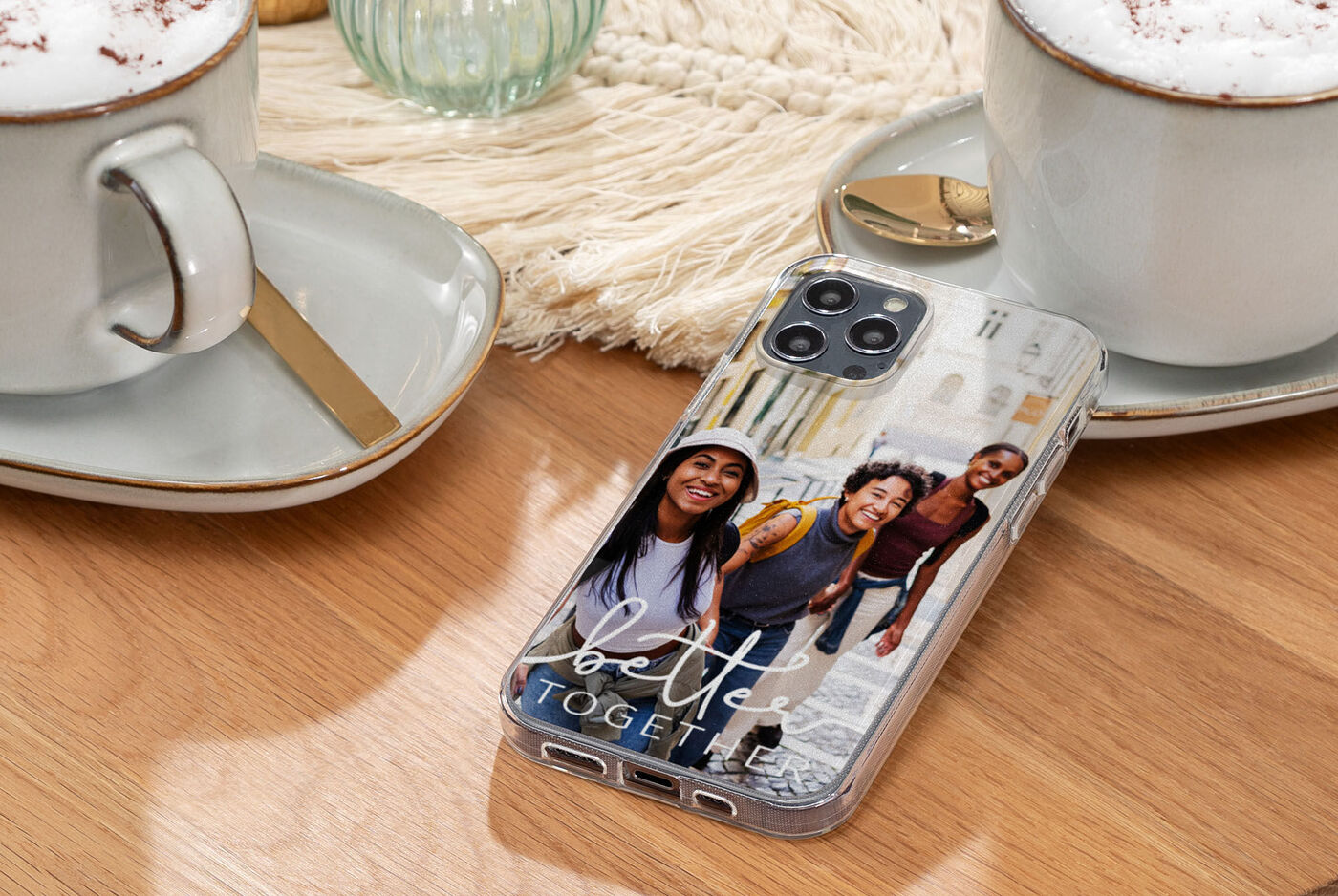 Handy mit individuellem Design und Foto von drei Personen bei Kaffee.